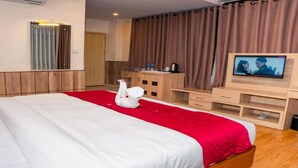 A hotel room with a bed, a TV, a desk, and a red carpet. - MeroStay 137 Hotel Eye (Lalitpur)