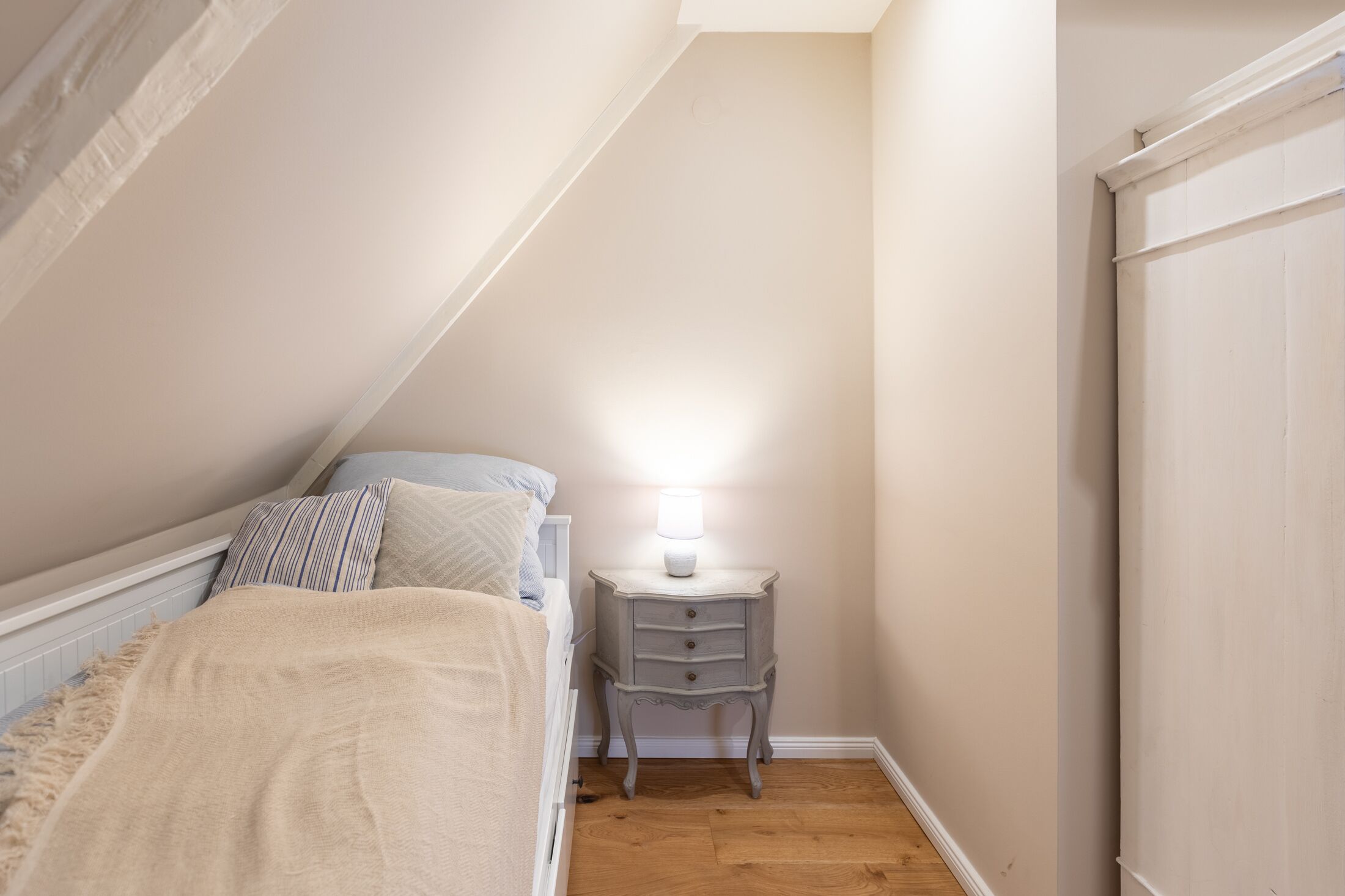 Ein Schlafzimmer mit einem Bett, einem Nachttisch mit Lampe und einem Kleiderschrank.