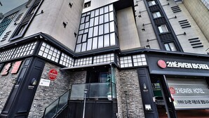 Et 2Heaven Hotel med en moderne facade, store vinduer og en markant indgang.