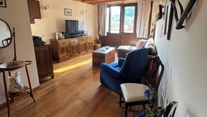 A wooden interior with a sofa, a television, and a dining area. - HOUSE IN THE VILLAGE OF CIRIEÑO (Cirieño- Amieva)
