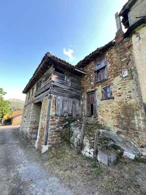 An old stone building with wooden windows and a weathered facade.