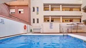En flervåningsbyggnad med en swimmingpool, balkonger och en livboj.