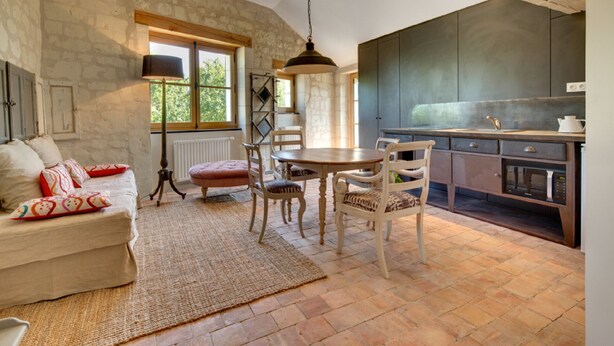 A cozy living room with a sofa, chairs, a table, and a large window. - When heritage, art and well-being meet (CANDES SAINT MARTIN)