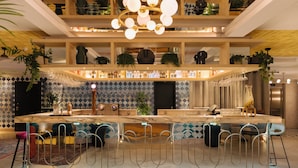 A modern bar area with a marble countertop, metal bar stools, and a variety of bottles and glasses. - Pestana Rua Augusta - Lisboa (Lisbon)