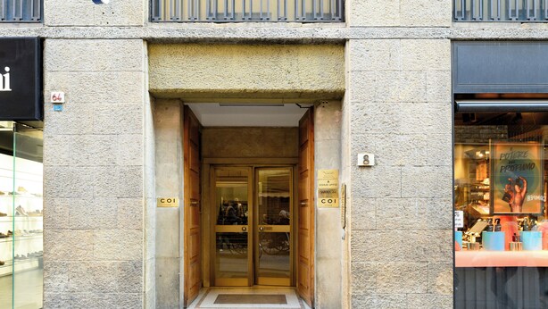 A hotel entrance with a stone facade, double doors, and a small step leading up to the entrance. - Domus Uffizi (Florence)