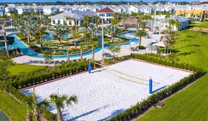 Un resort con una amplia playa de arena, varias piscinas y una hilera de villas al fondo.