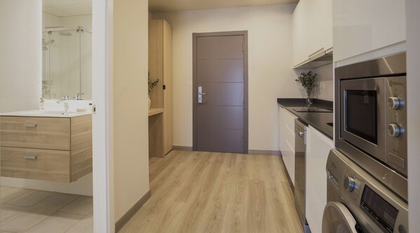 A modern bathroom with a shower, sink, and wooden vanity. - Housing Atarazanas by Sharing Co (Málaga)