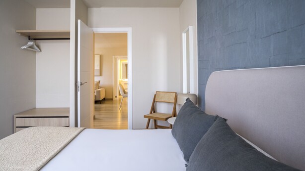 Ein Schlafzimmer mit Bett, Stuhl und Kleiderschrank.