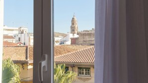 Blick durch ein Fenster mit einer Tür, der ein Gebäude mit Kuppel und Glockenturm zeigt, was auf eine historische oder religiöse Stätte hindeutet.
