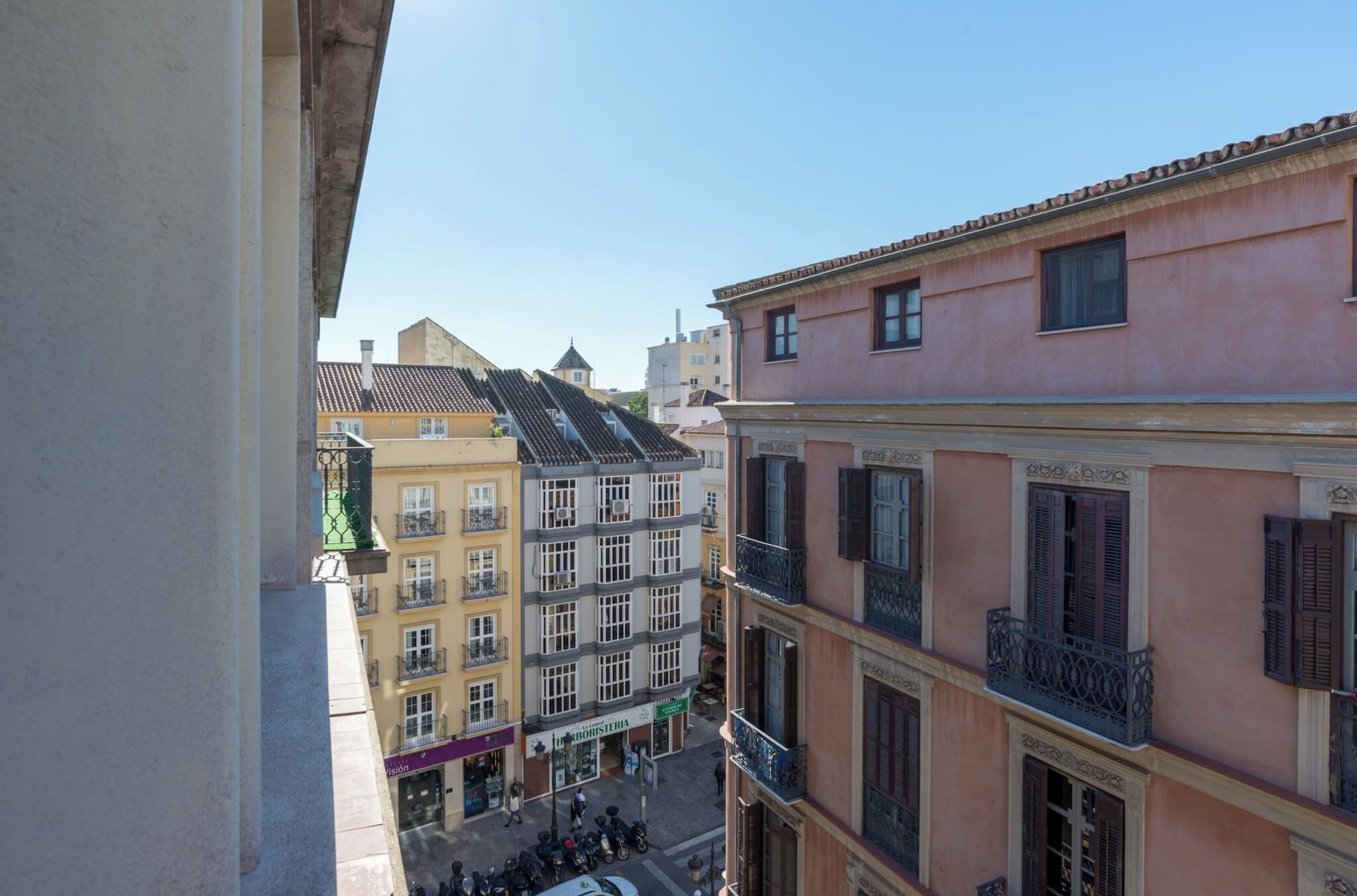 A multi-story building with balconies and a street view.