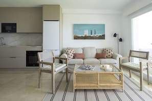 A modern living room with a sofa, two chairs, a coffee table, and a cityscape painting on the wall.