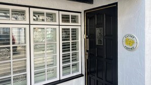 A black door with a white sign reading "Gannet Cottage."
