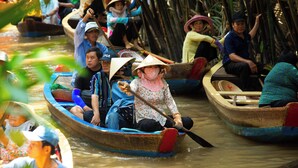 A group of people in traditional boats on a river. - The Rice Hotel & Tour - 40 Bui Vien No 9 (Ho Chi Minh City)