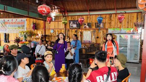 A restaurant interior with wooden walls, hanging lanterns, and a group of people seated at tables. - The Rice Hotel & Tour - 40 Bui Vien No 9 (Ho Chi Minh City)
