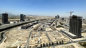 Vista aérea de un paisaje urbano con numerosos rascacielos, carreteras y obras en construcción.