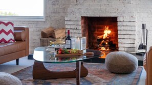 A cozy living room with a glass coffee table, a fireplace, and a comfortable sofa. - Halcyon– Breathtaking ocean views (Kiama Heights)