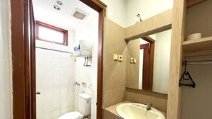 Ein Badezimmer mit Toilette, Waschbecken, Spiegel und Dusche.