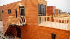 Un edificio moderno de madera con un balcón y una escalera.