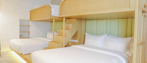 A hotel room with bunk beds, a wooden staircase, and a neutral color scheme.