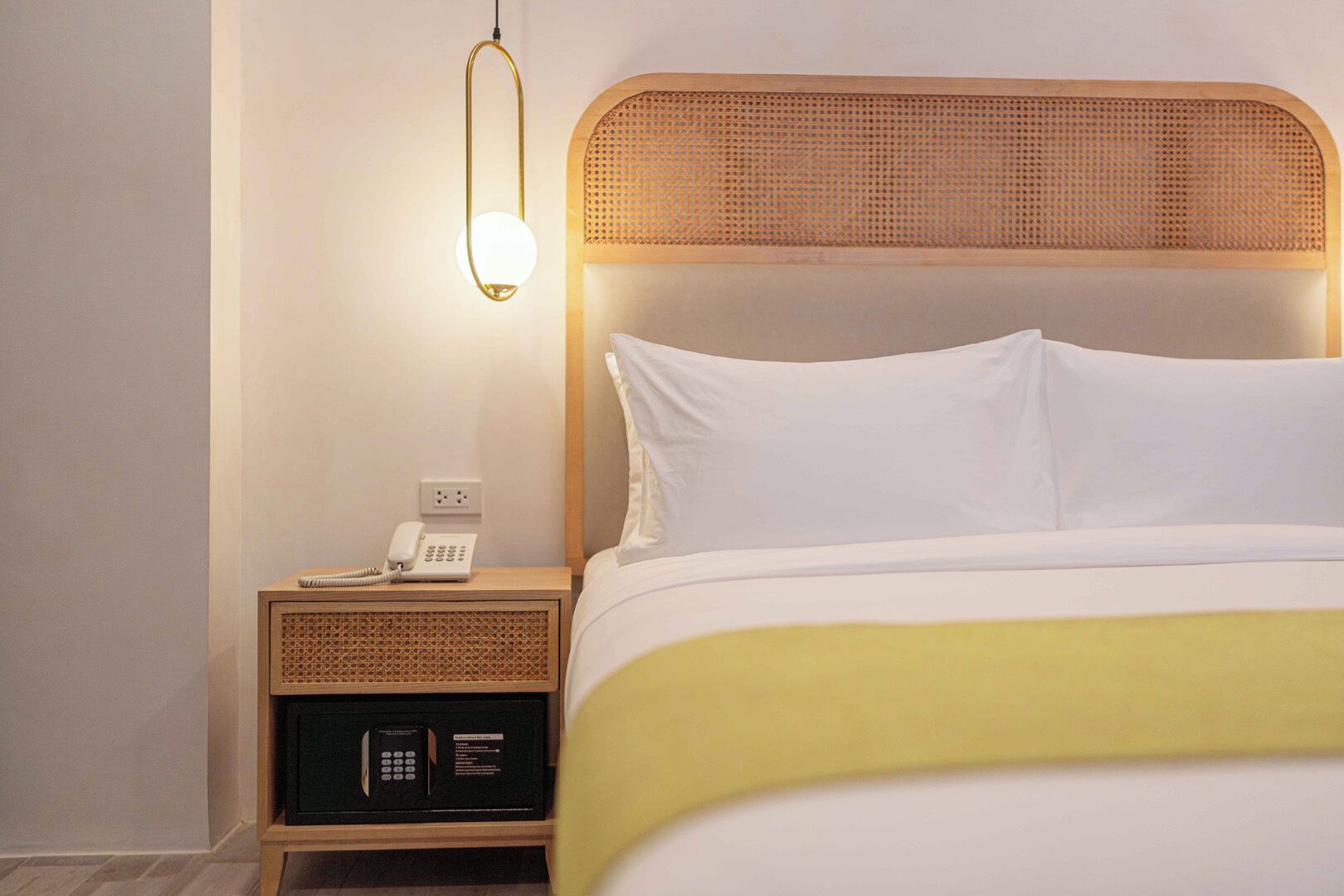 Une chambre d’hôtel avec un lit, une table de chevet, une lampe et un téléphone.