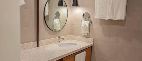 A bathroom with a sink, mirror, towel rack, and two pendant lights.