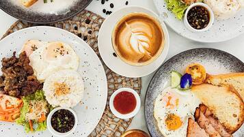 Un assortiment de plats pour le petit-déjeuner, notamment des œufs, des saucisses, des toasts et du café.