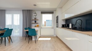 Eine moderne Küche mit weißen Schränken, einer Holzarbeitsplatte und einem Fenster mit Blick auf die Stadt.