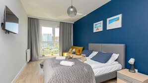 Ein modernes Schlafzimmer mit Bett, Nachttisch und Blick auf die Stadt.