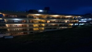 Un hotel a più piani con balconi e finestre illuminate.