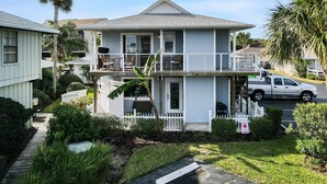 Une maison à deux étages avec un balcon, un garage et une allée.