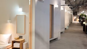 A modern hotel interior with a long corridor, minimalist decor, and a high ceiling. - KW2 Hostel   (Kaohsiung)