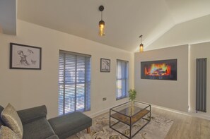 A living room with a sofa, a coffee table, and framed artwork on the walls.