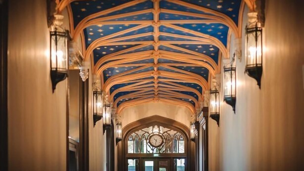 An interior with a starry blue ceiling, wooden beams, and wall-mounted lights. - Airinis (Isle of Lewis)