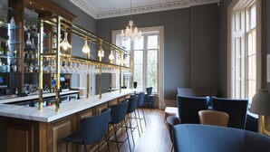 A bar area with a marble countertop, bar stools, and a wine rack. - Seaforth South (Isle of Lewis)