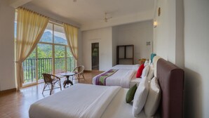 Une chambre d’hôtel avec deux lits, un balcon avec une chaise et une vue sur les montagnes.