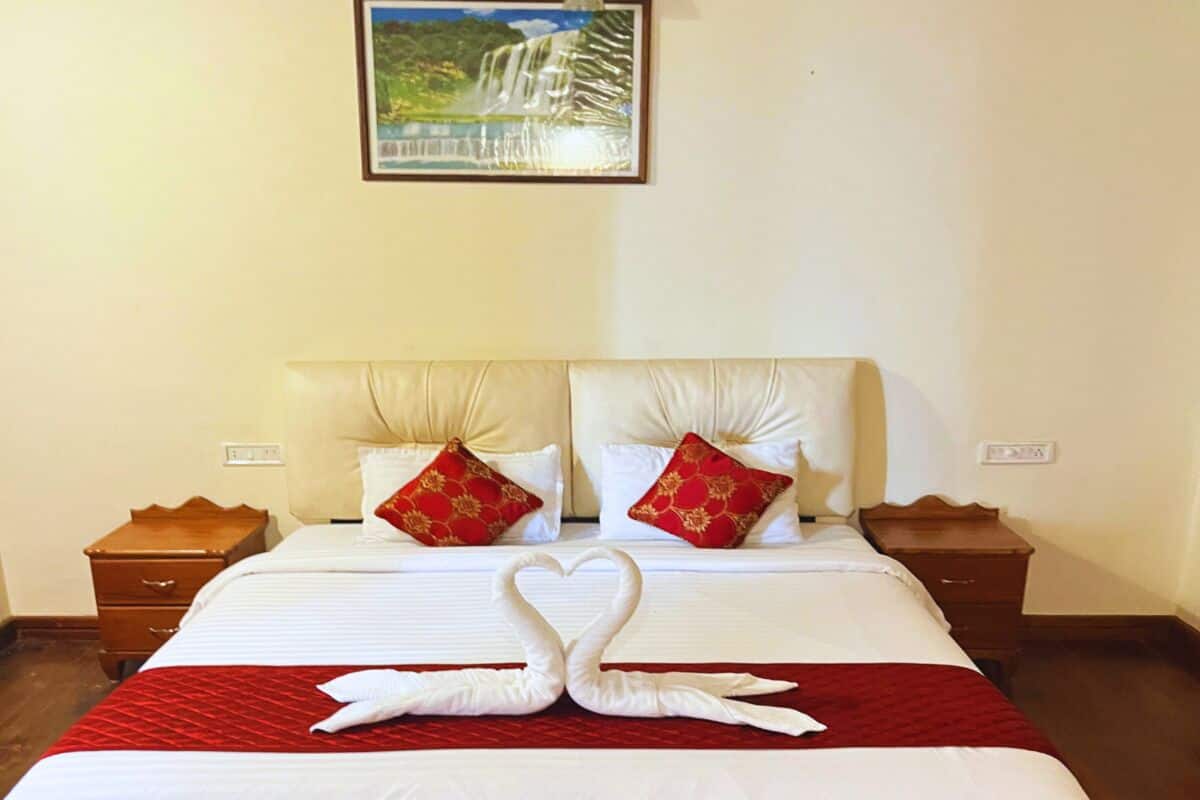 Ein Hotelzimmer mit einem großen Bett, zwei Nachttischen und einem Bild an der Wand.
