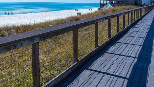 A wooden boardwalk leading to a beach with a restaurant named "Whale's Tail" in the background. - Seascape Villa 92F *Beach access and multiple pools! (Miramar Beach)