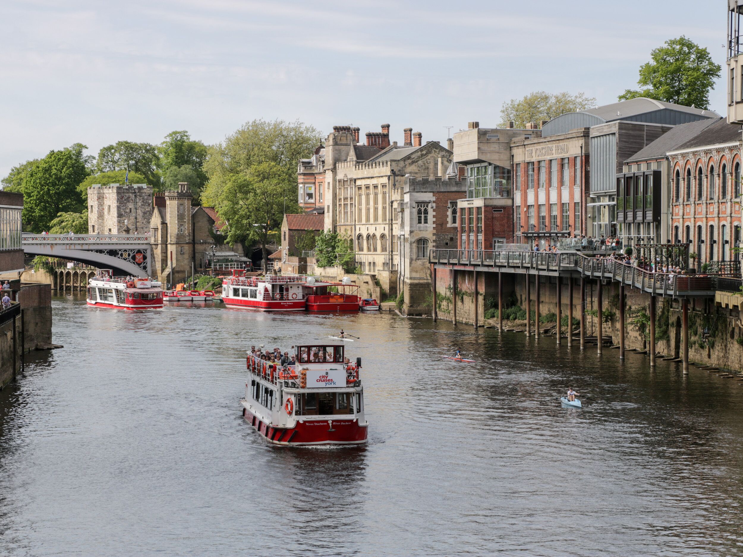 A river with boats, a bridge, and historic buildings along the banks.
