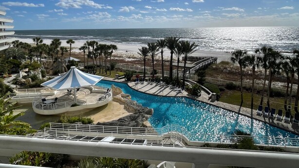 Zona de piscina con vista a la playa y al océano.
