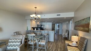 Un amplio espacio de sala con una mesa de comedor, sillas y una cocina al fondo.