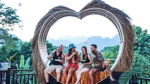 A heart-shaped structure with people sitting inside, overlooking a mountainous landscape. - Mad Monkey  Vang Vieng (Vang Vieng)