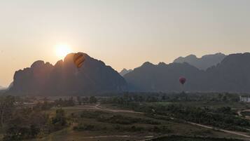 A landscape with mountains and two hot air balloons.