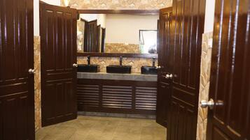 A bathroom with two sinks, a mirror, and wooden doors.