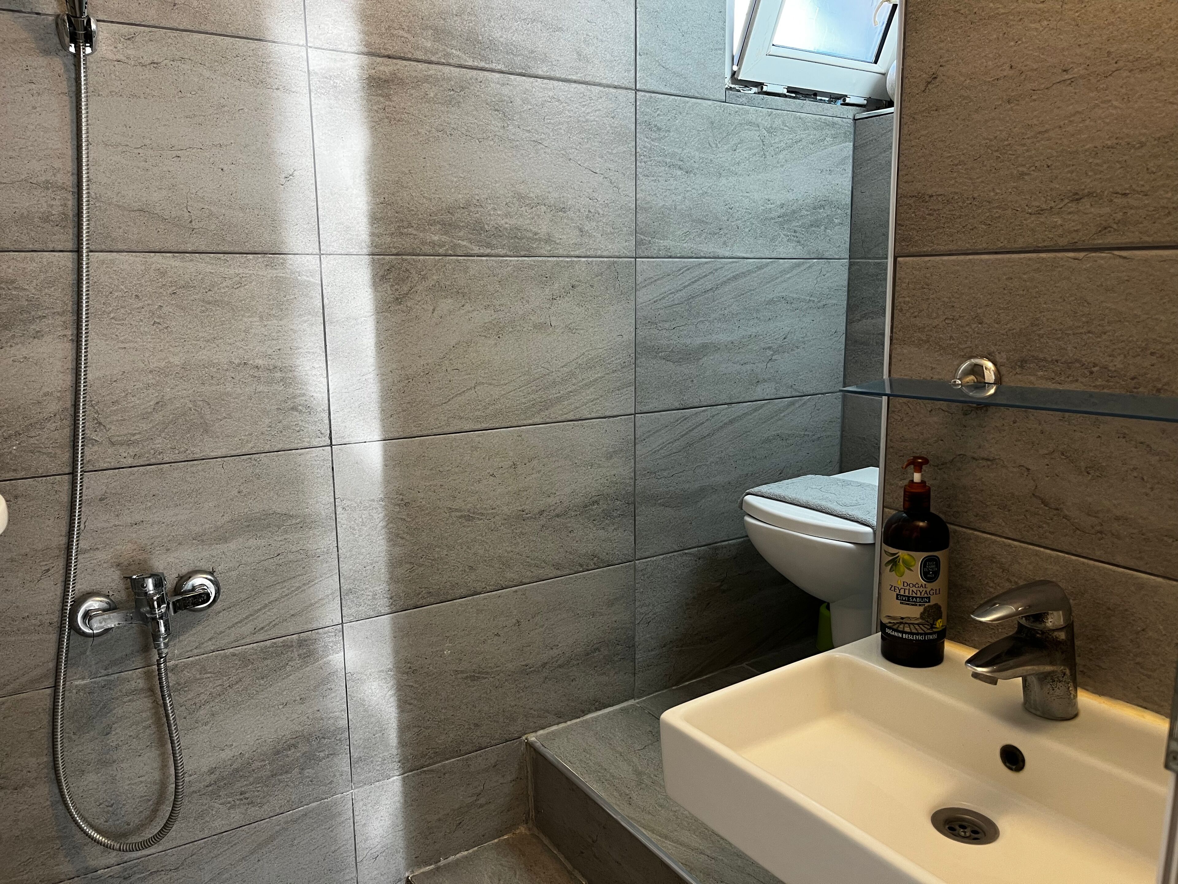 A bathroom with a shower, toilet, and sink.
