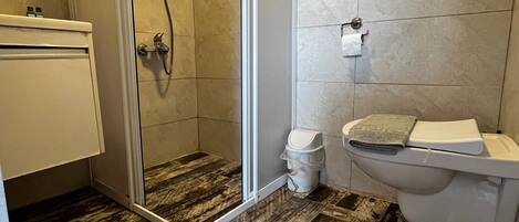 A bathroom with a shower, toilet, and sink.