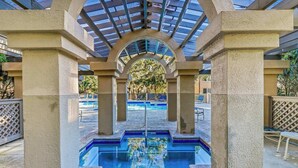 A pool area with a glass ceiling and concrete pillars. - 145 Colonnade Club Villa Beach Path, Pool, Hot Tub (Hilton Head Island)