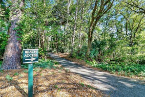 A forested path with a sign indicating beach access to the right. - 145 Colonnade Club Villa Beach Path, Pool, Hot Tub (Hilton Head Island)