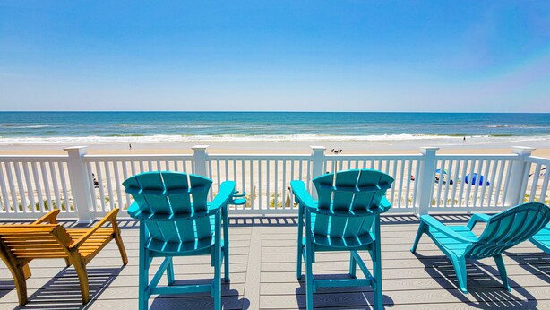 A wooden deck with turquoise Adirondack chairs and a wooden bench overlooking a beach. - Mermaid Cove – Splash Into Relaxation (North Topsail Beach)