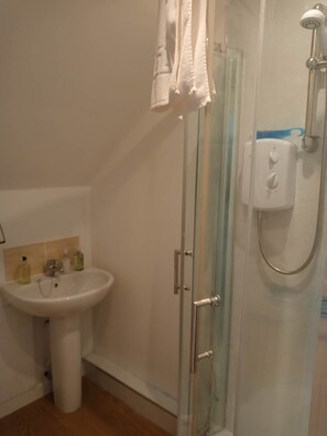 A bathroom with a glass-enclosed shower, a pedestal sink, and a towel hanging on the door. - Close to the Seaside - Sleeps 4/free Wifi/parking (Leven)