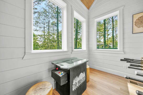 A room with large windows, a pool table, and a wooden floor. - Luxury Treehouse! Elevated, Magical & Unique! (Broken Bow)
